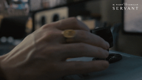 Mano con un anillo en el dedo, maniobrando una cámaras de seguridad.